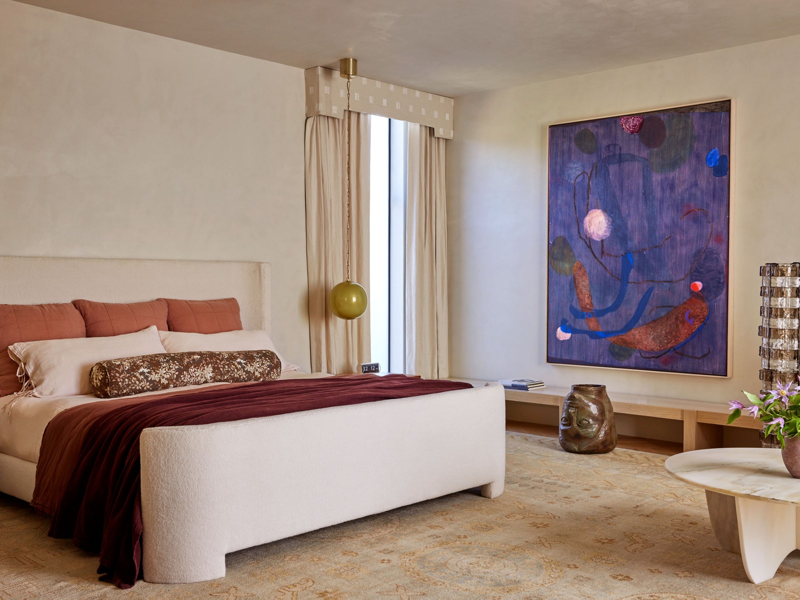 Primary bedroom with large Turkish area rug abstract purple painting on wall