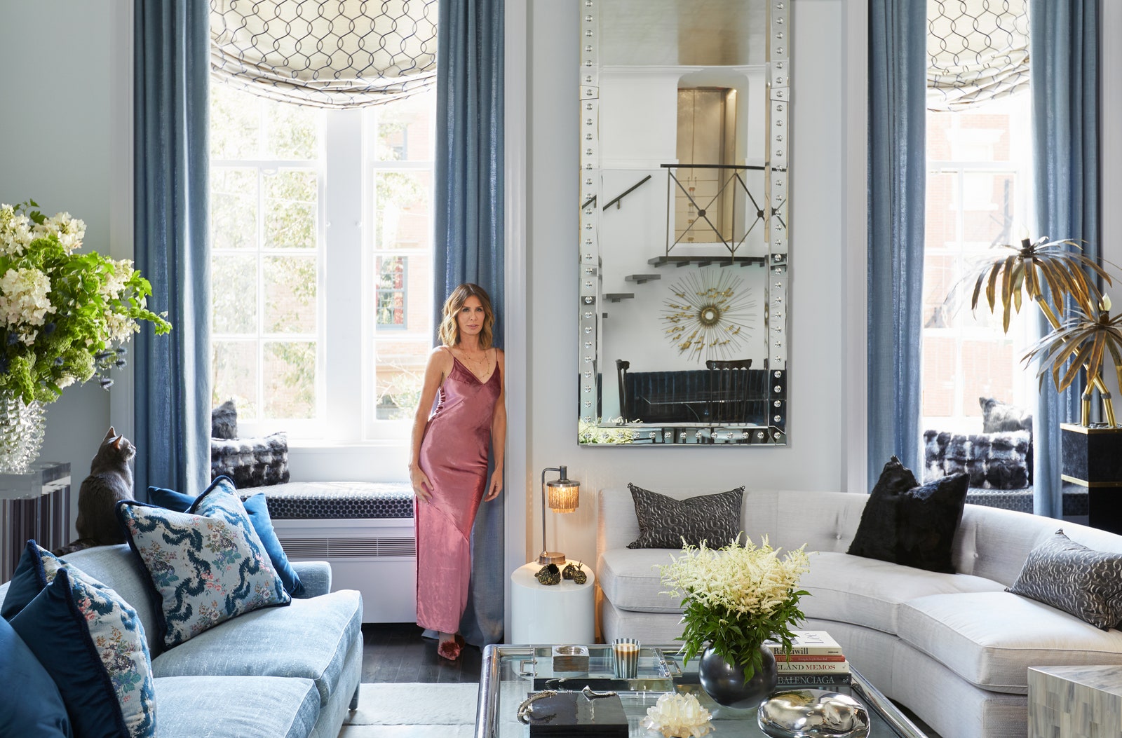 “Real Housewives of New York” alum Carole Radziwill in pink dress standing in living area with bay window blue curtains...